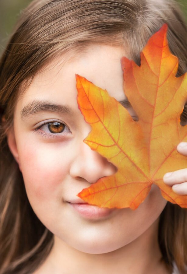 children-portrait-girl-with-maple-leaf-in-fall